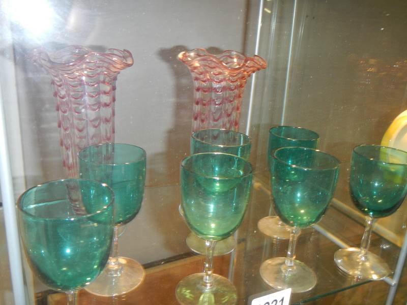 A pair of overlaid glass vases and a quantity of green glass goblets.