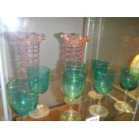 A pair of overlaid glass vases and a quantity of green glass goblets.