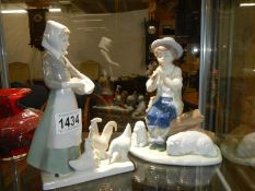 A NAO figure of a boy with sheep and a girl with geese.