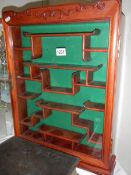 A Chinese mahogany display cabinet with shaped shelves.