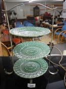 A three tier EPNS cakes stand with three green plates.