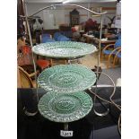 A three tier EPNS cakes stand with three green plates.