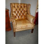 A leather deep buttoned wing arm chair, COLLECT ONLY.