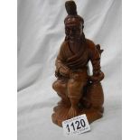 A carved wood figure of an oriental gentleman with bone teeth,