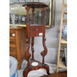 A 20th century mahogany wig stand with two drawers.
