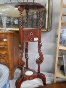 A 20th century mahogany wig stand with two drawers.