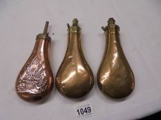 Three Victorian copper gun powder flasks.