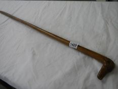 A fruitwood walking stick with carved dog head handle.