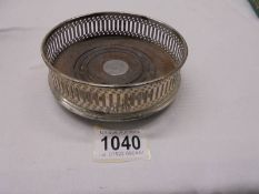 A hall marked silver wine bottle coaster with mahogany base.