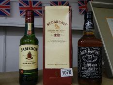Three bottles of whisky - Redbrest, Jamesons and Jack Daniels.