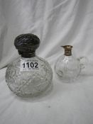 A silver topped perfume bottle and a glass jug with silver spout missing stopper.