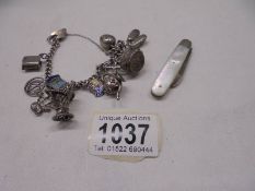 A silver bracelet with charms (42 grams) and a silver fruit knife.