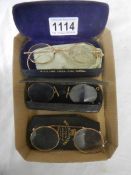 Three cased pairs of vintage spectacles.