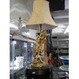 A large figural table lamp with shade.