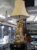 A large figural table lamp with shade.