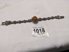 A silver marcasite bracelet set central amber stone.