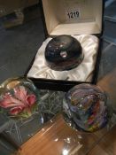 A boxed Caithness glass paperweight and two others.