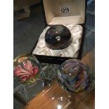 A boxed Caithness glass paperweight and two others.