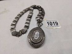 A Victorian silver locket on a decorative un-marked chain.