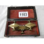 An unusual cased brass measuring item.