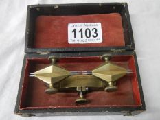 An unusual cased brass measuring item.