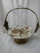 A WMF brass mounted cake stand with ceramic cake plate.