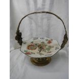 A WMF brass mounted cake stand with ceramic cake plate.