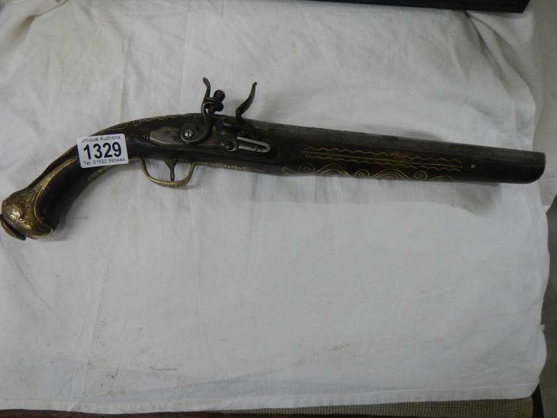 A 19th century flint lock pistol with brass inlay.