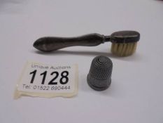 A 1903 Birmingham silver moustache brush and a silver thimble.