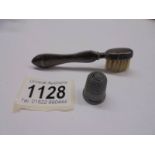 A 1903 Birmingham silver moustache brush and a silver thimble.