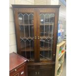 A dark oak corner cupboard with leaded glass doors (COLLECT ONLY)