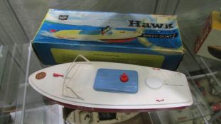 A Sutcliffe Merlin battery operated tin plate boat and an empty box for a Hawk clockwork speedboat.