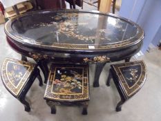 A large oval black lacquered coffee table with six small nesting tables, COLLECT ONLY.