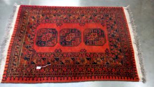 A red & black Middle eastern geometric patterned rug - 165cm x 102cm. COLLECT ONLY