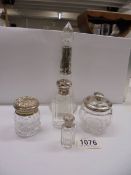 Two silver topped bottles, two silver topped jars and a silver collared scent bottle.