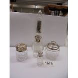 Two silver topped bottles, two silver topped jars and a silver collared scent bottle.