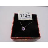 A diamond set pendant with an amethyst centre stone in 9ct gold on a 9ct gold chain.