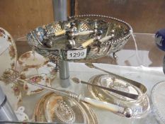 A silver plate basket, toasting fork, sugar tongs and two pairs of knife rests.