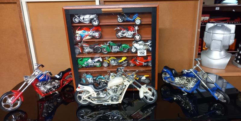 A collection of plastic motorbike models including a display case