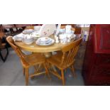 A solid light wood round-to-oval extending dining table and 4 chairs D105cm H79cm, COLLECT ONLY