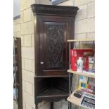 A Georgian oak corner cupboard with carved door (COLLECT ONLY)
