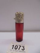 A ruby glass scent bottle with silver top.