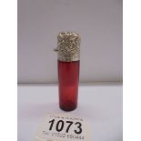 A ruby glass scent bottle with silver top.