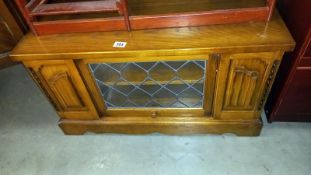 An oak TV stand with leaded glass door, COLLECT ONLY