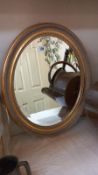 An oval gilt framed bevel edged mirror. approximately 50cm x 60cm. COLLECT ONLY