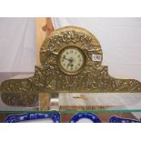 An arts & crafts hammered brass 8 day mantel clock decorated with leaves & grapes, in working order.