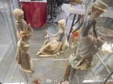 Three Lladro figurines - Girl with dove, Girl with hen and elegant lady