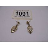 A pair of gold earrings set cameos. 1.9 grams.