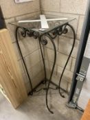 A tall glass topped wrought iron lamp/plant stand height 110cm, slight chip to edge of glass (