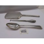 A hall marked silver backed hand mirror, a silver spoon and a silver handled button hook.